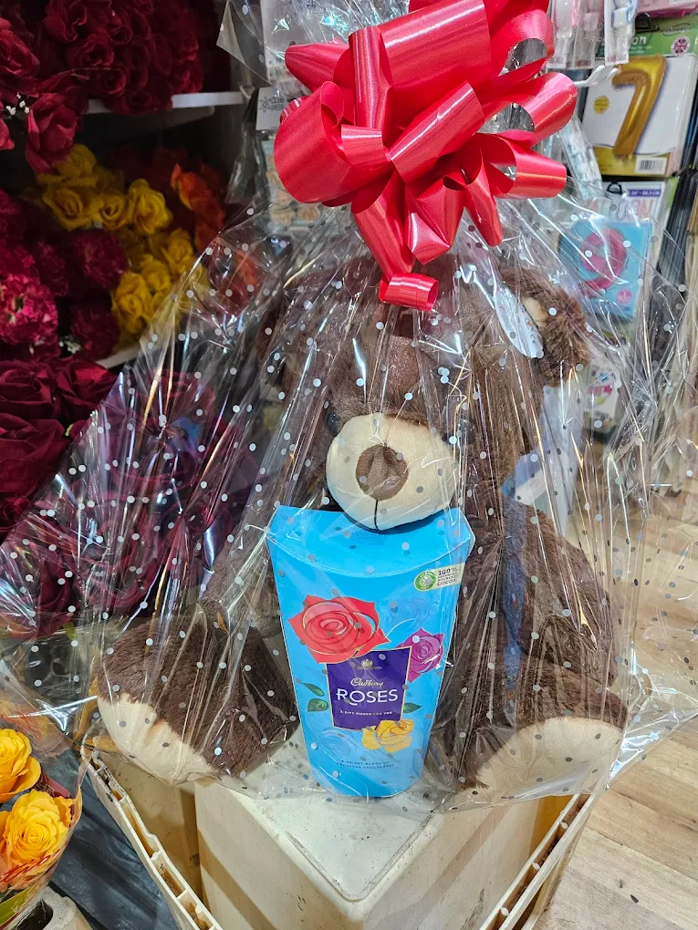 Fresh flowers paired with a teddy bear gift.