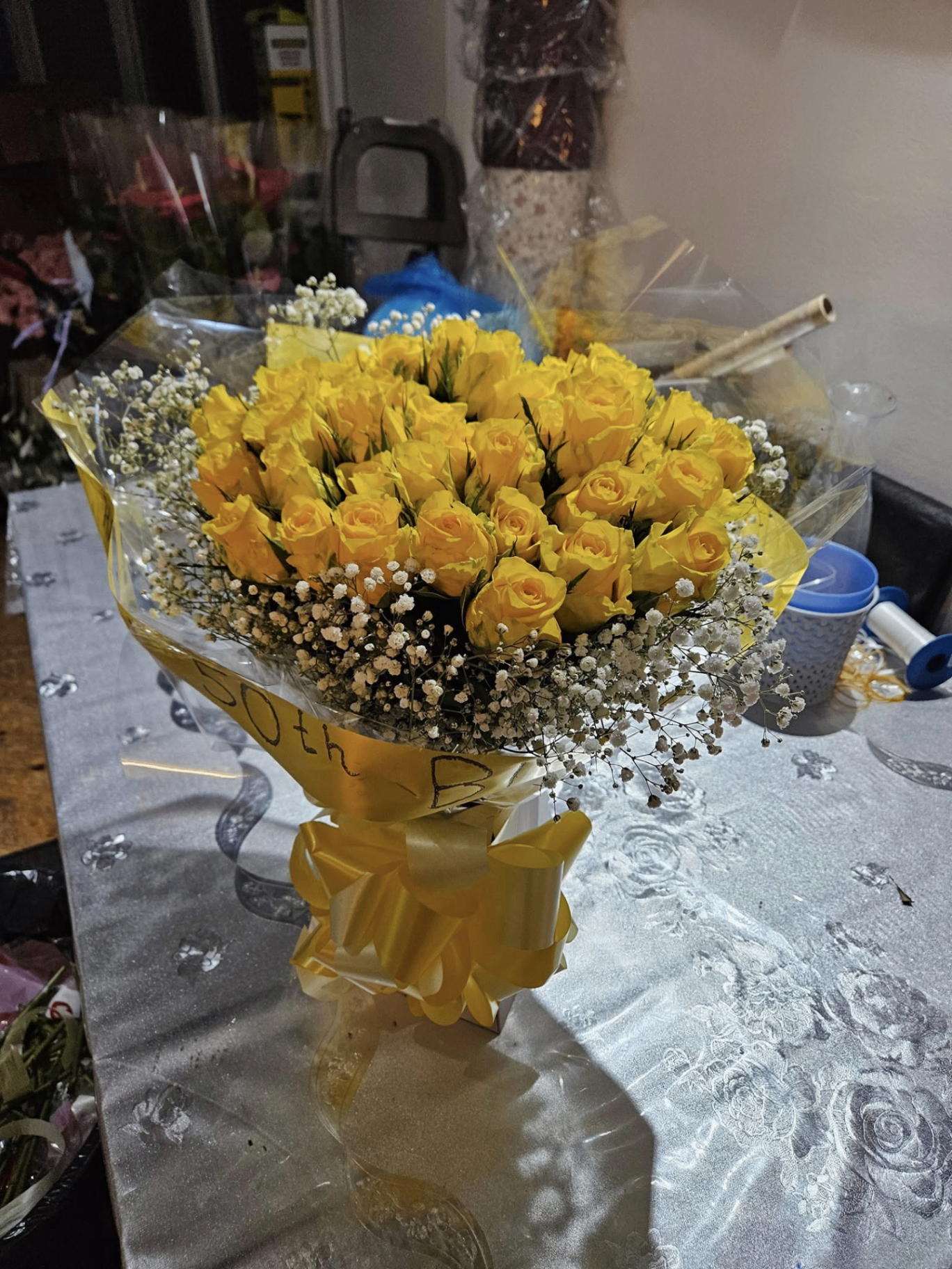 50th birthday yellow rose bouquet with gypsophila and gold ribbon.