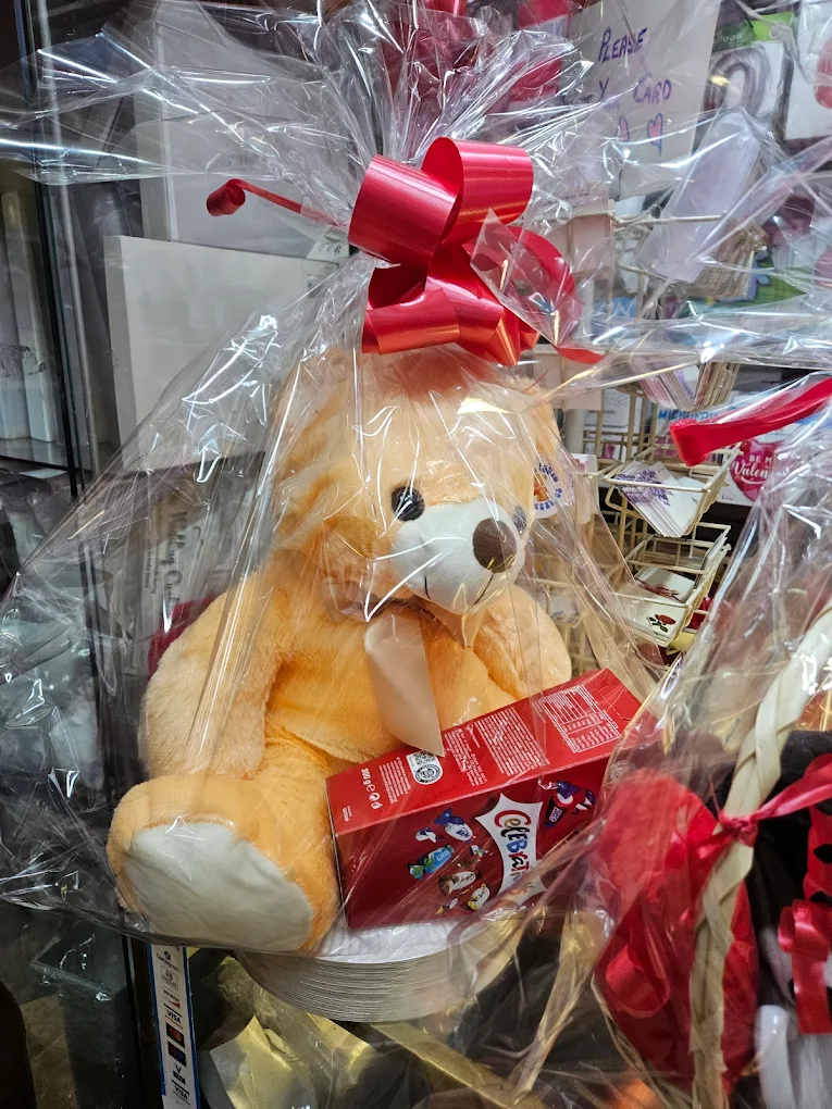 Newborn gift bundle with flowers, a bunny and chocolates.