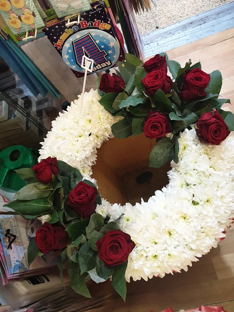 White wreath with red roses.