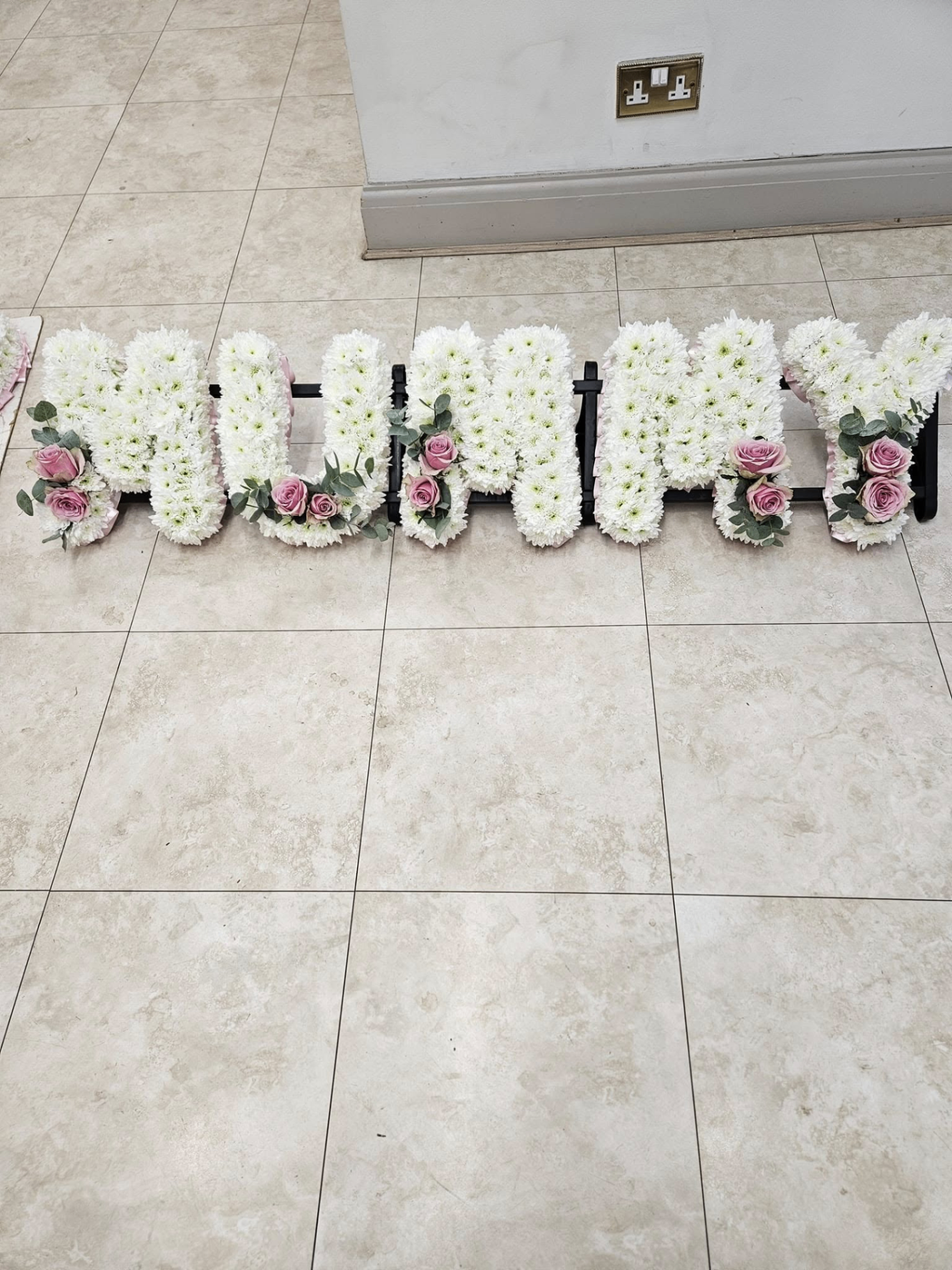 'MUMMY' floral letter tribute in white chrysanthemums with pink roses.